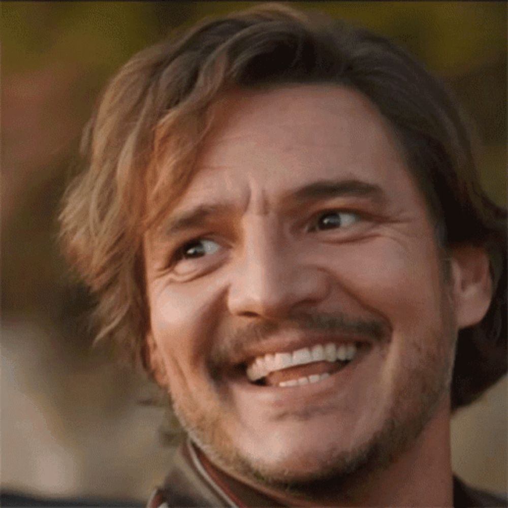 a close up of a man 's face with a beard and mustache smiling .