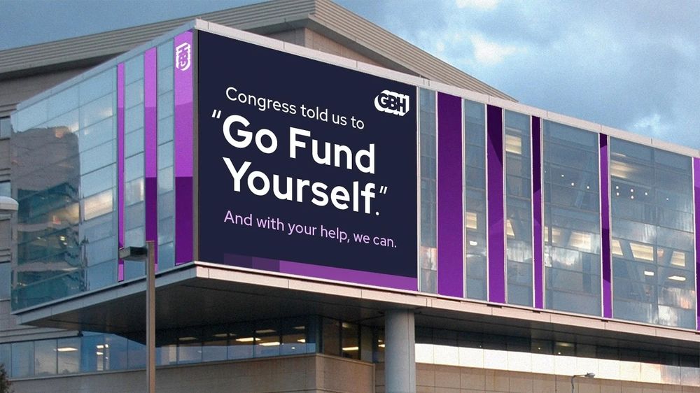 A billboard on the side of the GBH building in Boston, MA that says "Congress told us to 'Go Fund Yourself.' And with your help, we can"