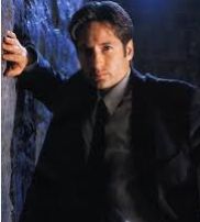 Special Agent Fox Mulder of the FBI leaning against a wall looking at the viewer.