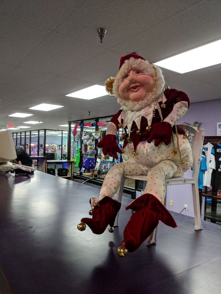 A really creepy Christmas doll thing that is maybe a clown or an elf or something, has one of them hard plastic faces, it's all bulging and shit. Sitting in a little chair on the counter at a run-down bowling alley. 