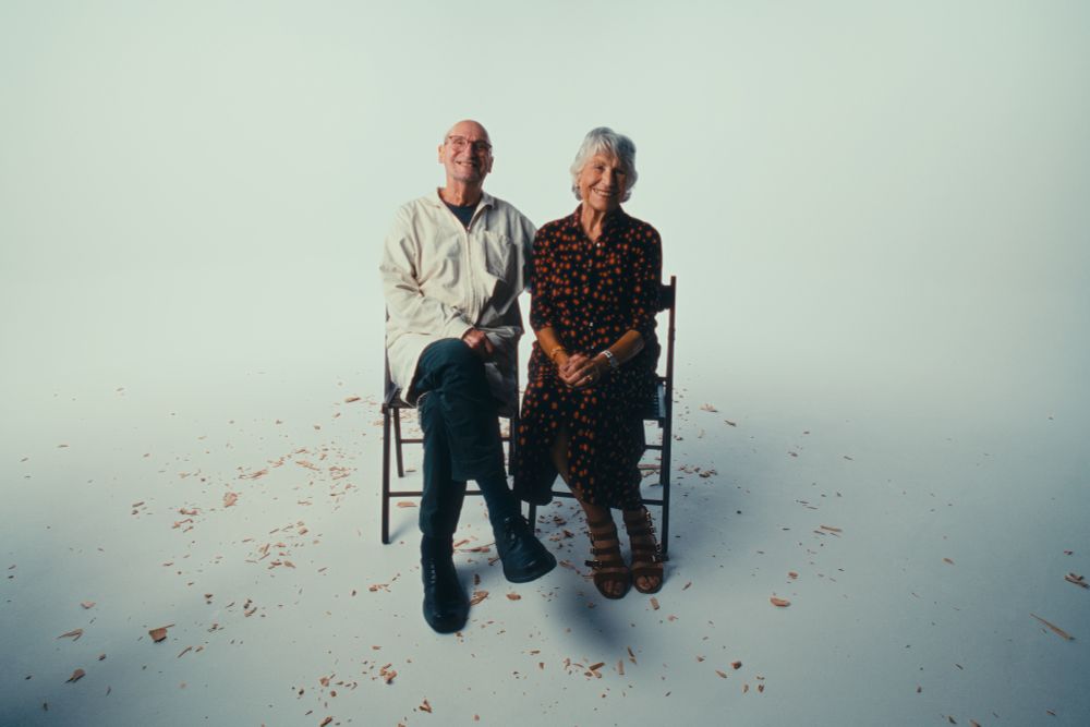 Master stone and wood carver Tony Webb and his wife Cecily seated amongst woodchips in an infinity cove studio