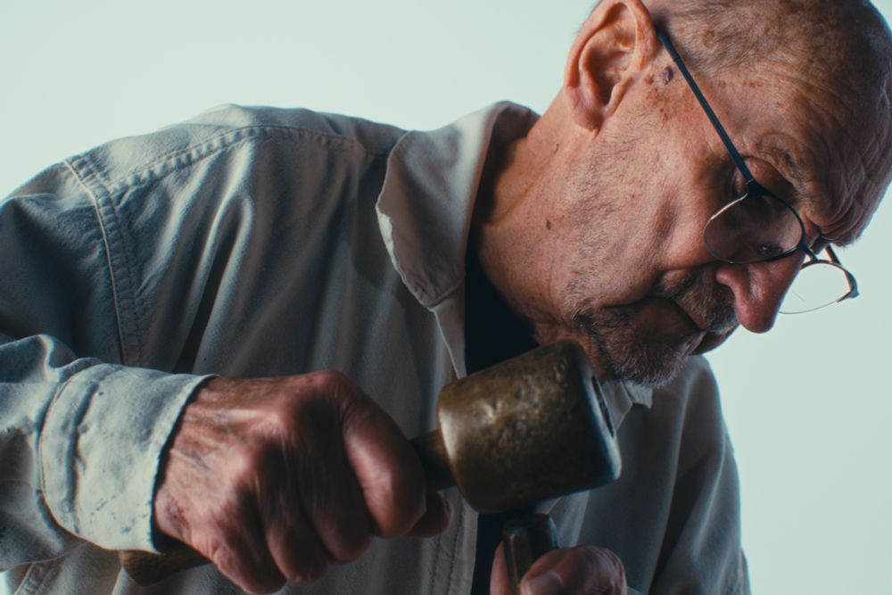 Close-up of Tony Webb, master stone and wood carver, with his chisel and mallet