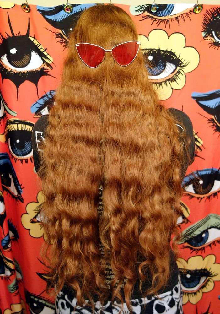 Photo of OP with butt-length wavy red hair before a donation haircut. Red sunglasses are perched on the back of OP's head to give the appearance of a stylish Cousin It.