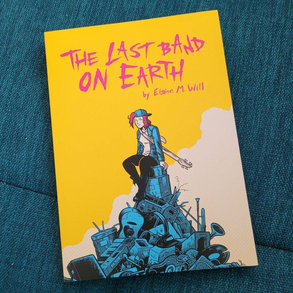 The Last Band On Earth, by Elaine M. Will. The cover artwork is bright yellow with pink lettering and depicts a woman wearing punk style clothing and a bass guitar slung over one shoulder, sitting on top of a pile of broken instruments.