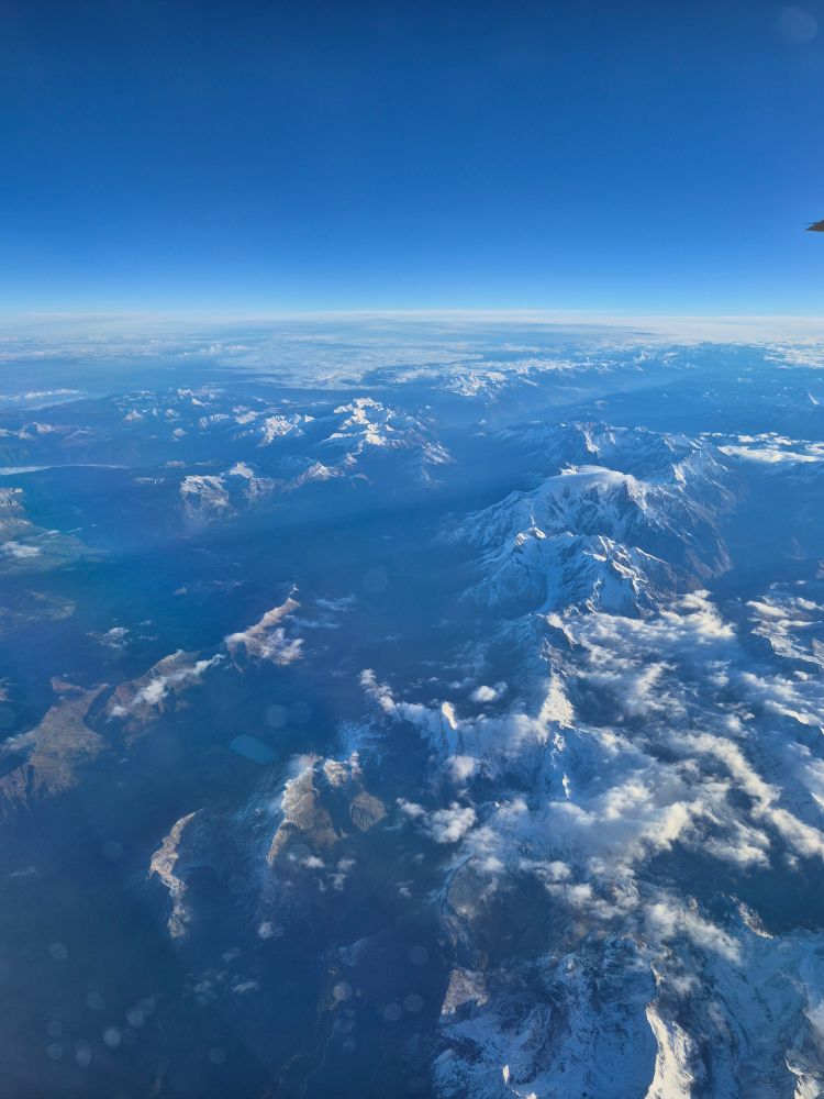 Photo of the Alps mountain range taken from a plane window.