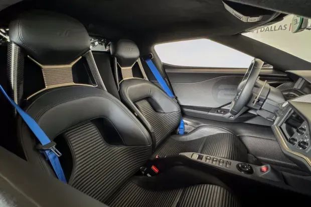 A close up of the black seats of a Ford GT with blue seatbelts.