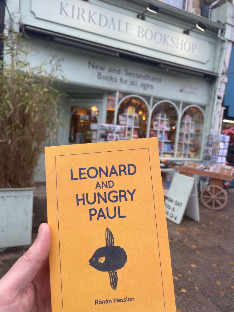 The distinctive yellow book Leonard and Hungry Paul by Ronan Hession with Kirkdale Bookshop SE26 in the background 