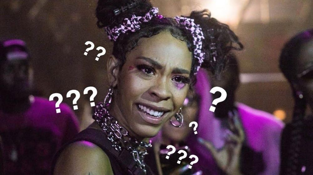 Close up of Rico Nasty looking confused with question marks around her. 