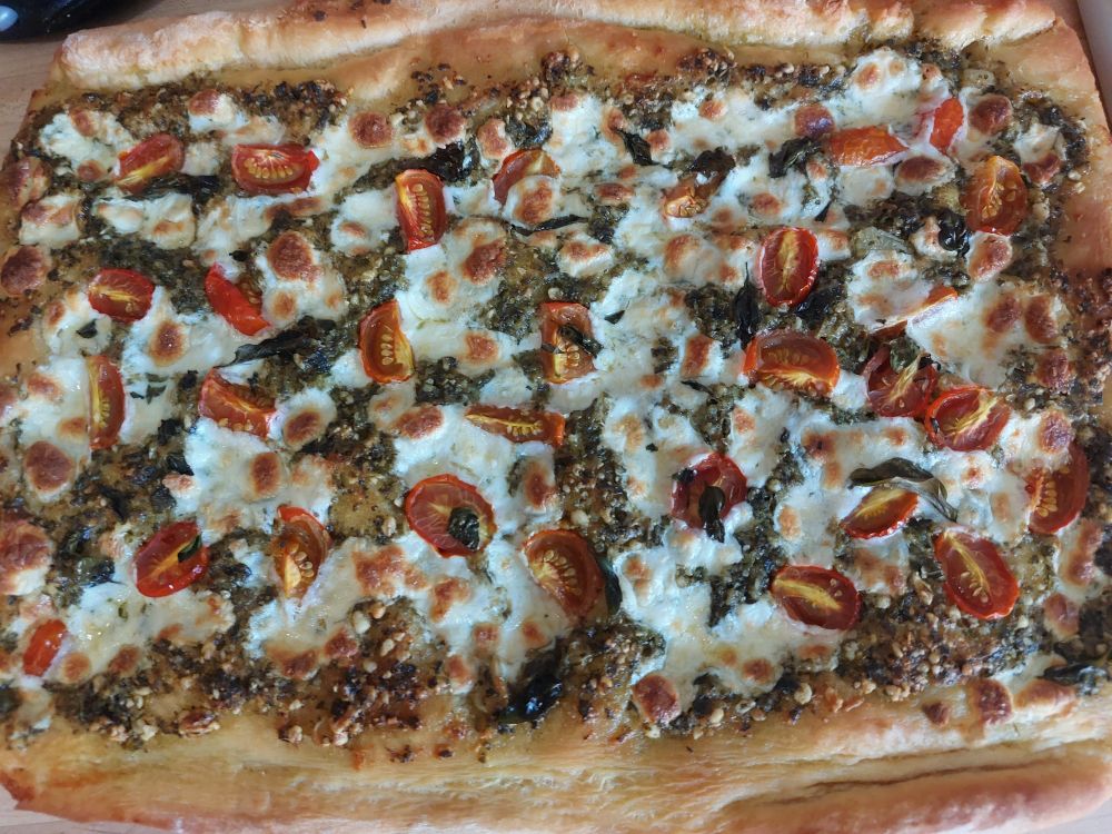 Pesto pizza with basil, tomatoes, and oregano from the garden 