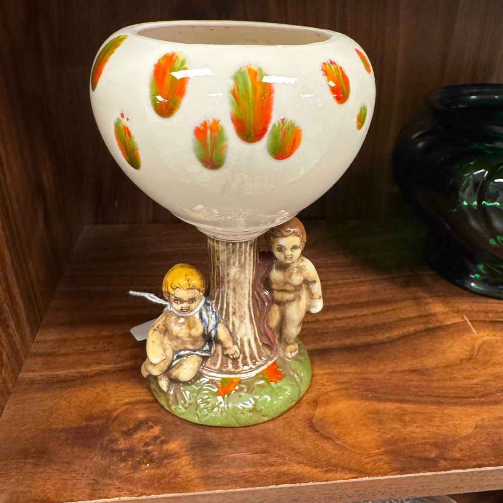 A weird 1970s-ish ceramic chalice/planter with two vaguely creepy cherubs at the base.