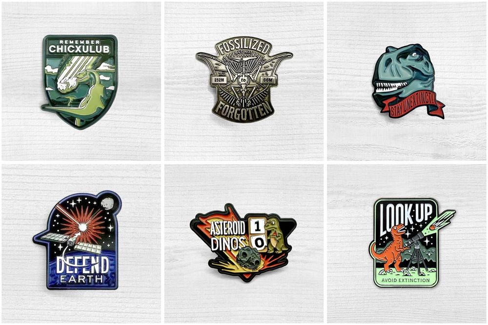 six enamel pins featuring the theme of the dinosaur extinction event. shown are various depictions of dinosaurs and asteroids one with a space mission theme. 