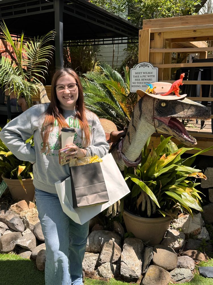 A girl standing in front of a fake raptor