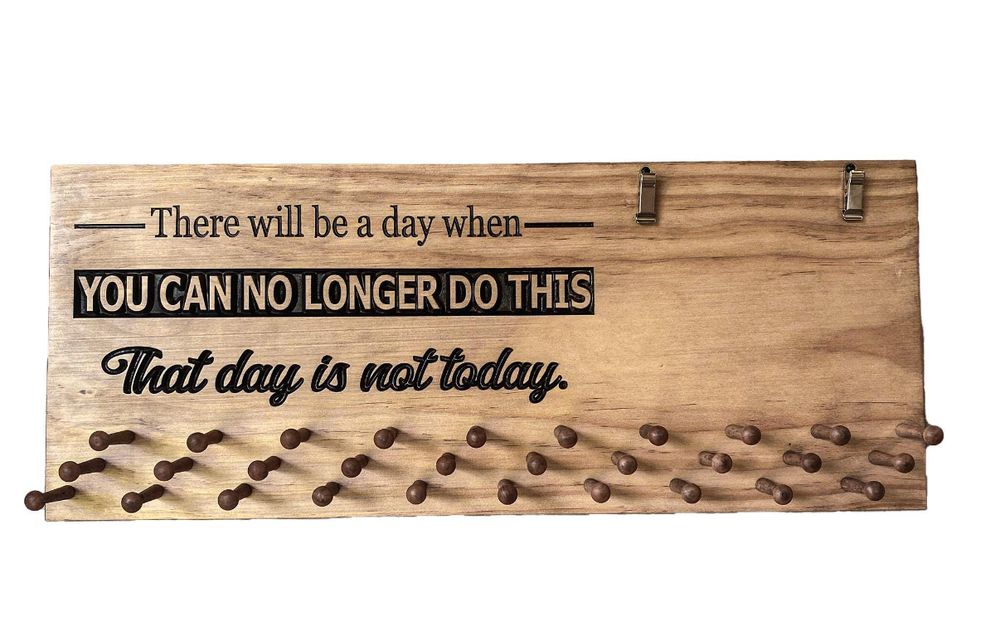 A lovely wooden equestrian ribbon hanger that says “There will be a day when you can no longer do this. That day is not today.”