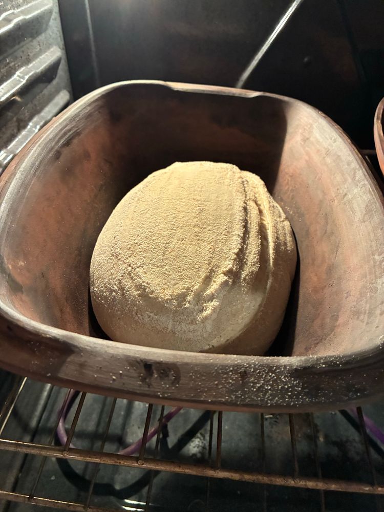 Just into the bottom of my hot clay baker, also inside the oven. 

I will cover it with a hot lid to bake. 