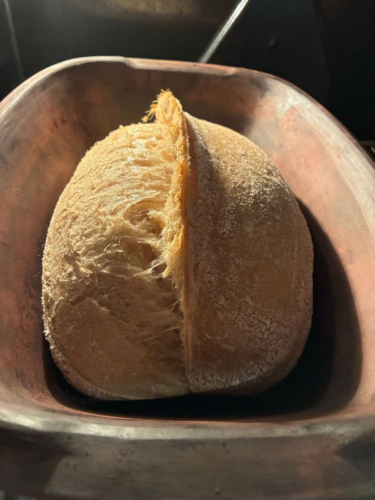 Uncovered loaf inside clay baker, now risen but only halfway done. It goes back in to finish and brown. 