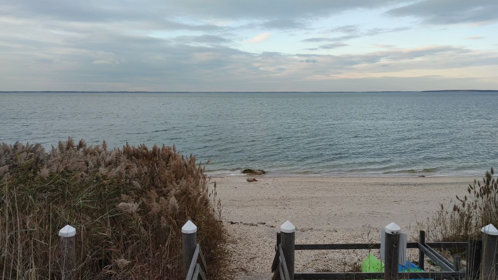 The white bay ahead, after a staircase and a sandy beach