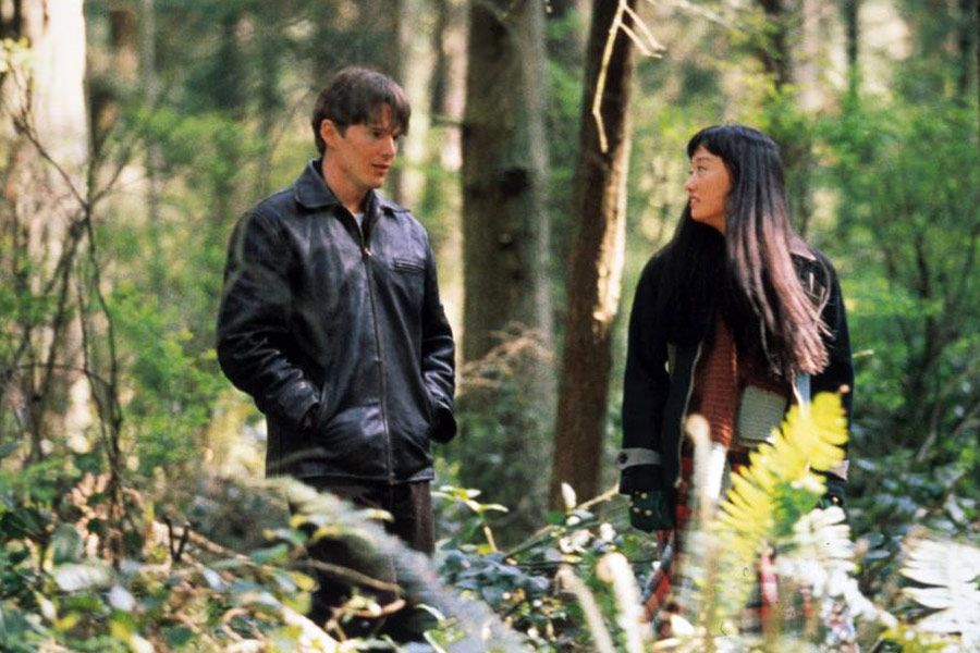 The characters Ishmael and Hatsue, looking at each other surrounded by trees and ferns