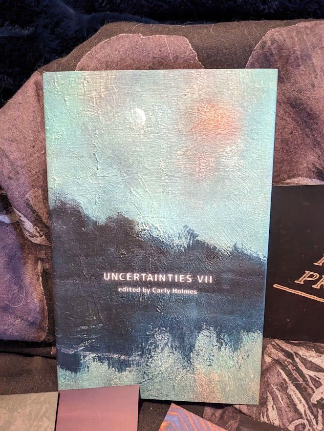 a closer shot of the cover of the anthology, which has a dust jacket on it that looks like a textured oil painting but is smooth
