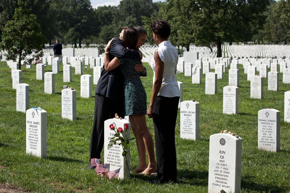 Barack Obama embraces a visitor at the Arlington National Cemetery in Arlington, VA with his wife Michelle