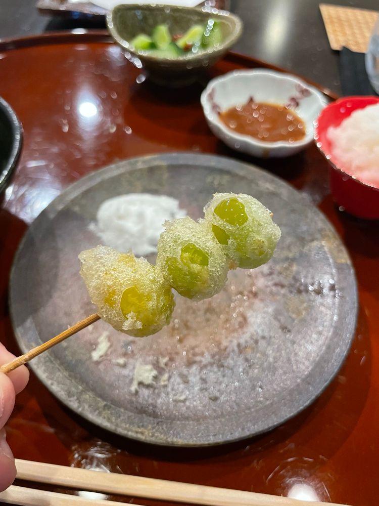 Three tempura fried ginkgo biloba on a toothpick