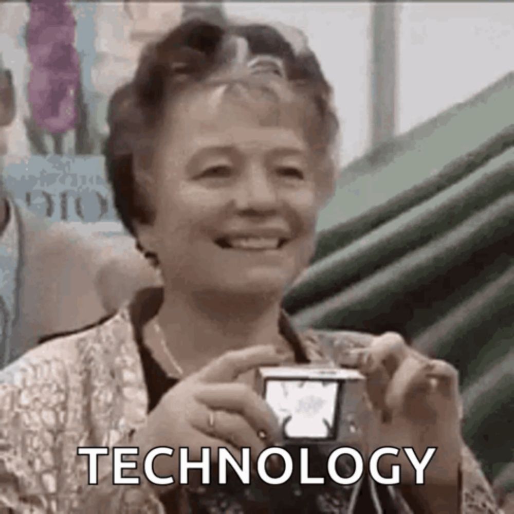 an elderly woman is smiling while holding a camera and the word technology is written on the screen .