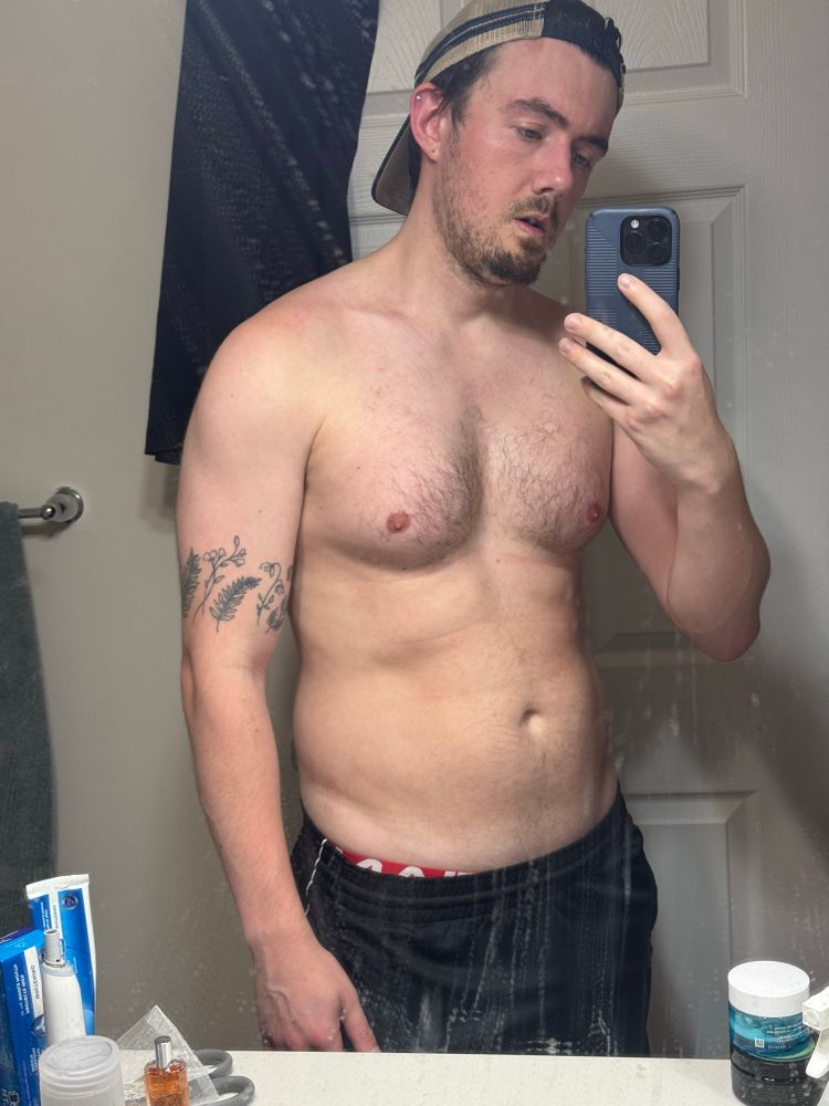 A very frumpy and sweaty looking gay boy in front of a disgusting mirror that hasn’t been cleaned since he moved into the apartment