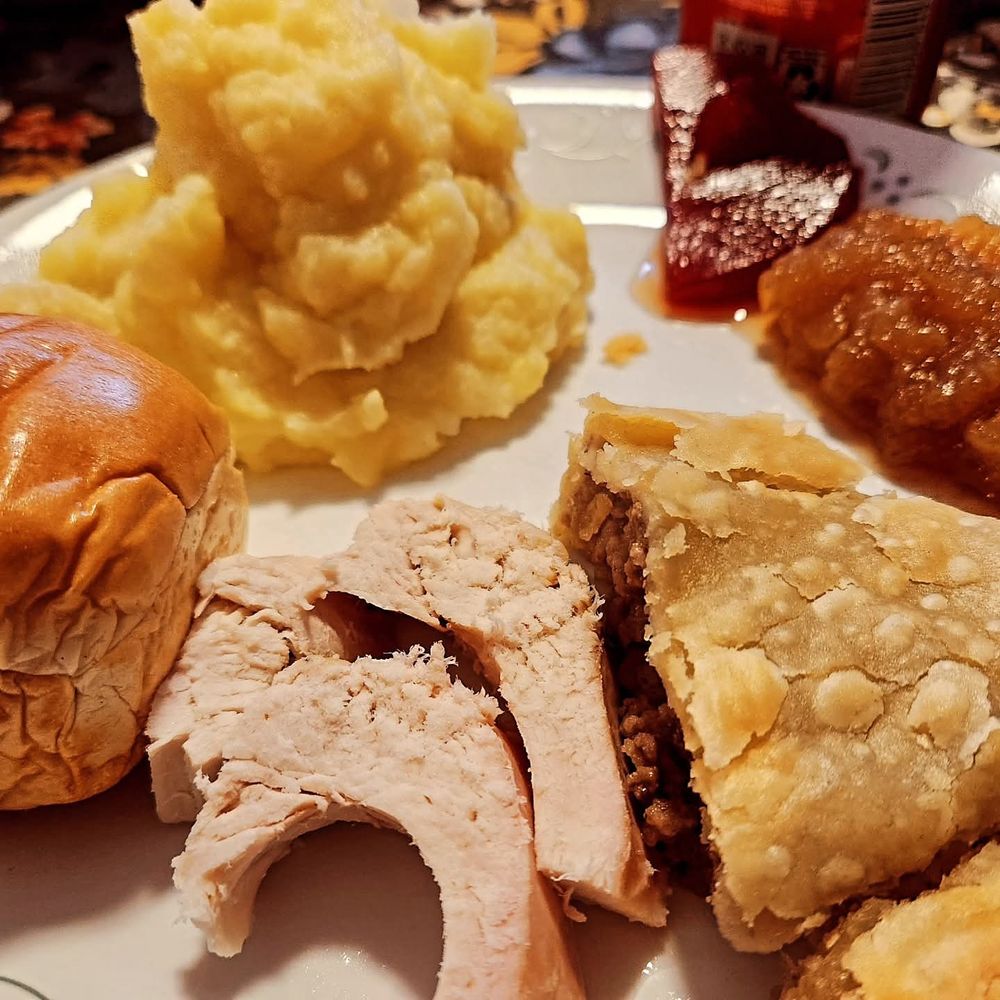 Turkey, pork pie, apple sauce, cranberry sauce, mashed potatoes, bun