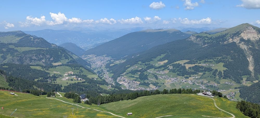 Panorama of alpine valley with high mountains,green pastures and woodland together with villages in the bottom of the valleys 