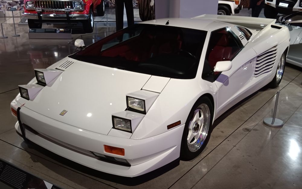 White Cizeta V16T, easily recognizable by its quad pop-up headlights.
The Cizeta was developed by automotive engineer Claudio Zampolli in a joint venture with music composer Giorgio Moroder, and designed by the great Marcello Gandini. It was developed by a group of ex-Lamborghini employees and initially introduced in Los Angeles in December 1988.
Giorgio Moroder would later part ways with the company and request his name be taken off of the cars.