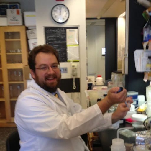 Professor of Biology at Ball State University, VJ Rubenstein, in a lab coat working at a research station.