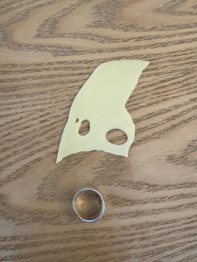 Picture. Piece of cheese above a ring making a "funny" face.