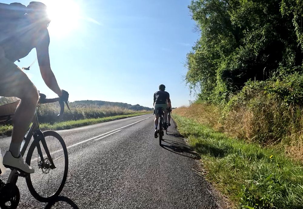 Picture. A group of cyclists on a sunny country road in France.