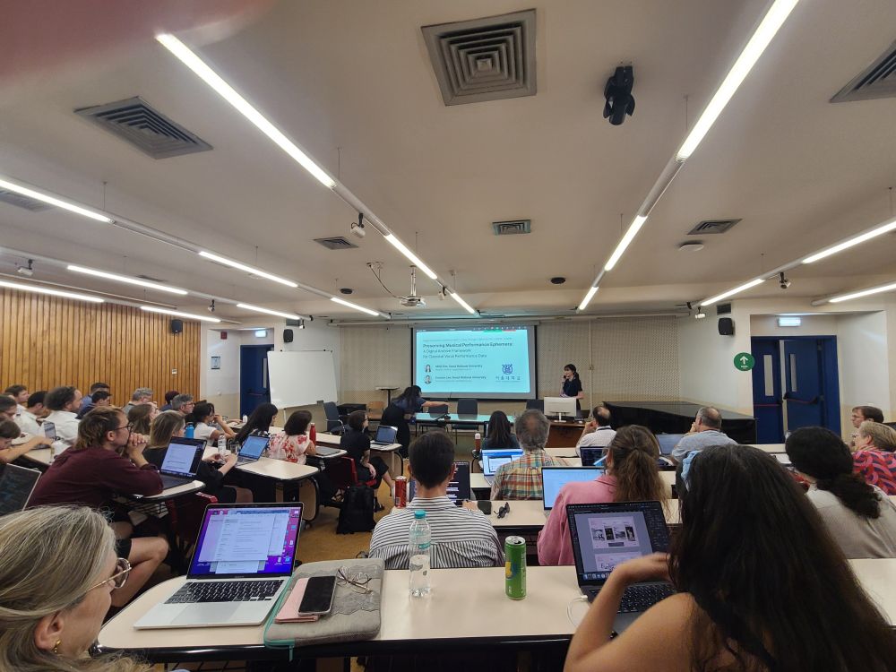 Picture of a conference session room full of people. 