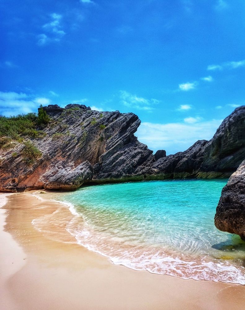 The coastline of Bermuda is dotted with small turquoise lagoons shielded from the ocean by a stonewall of jagged cliffs. 