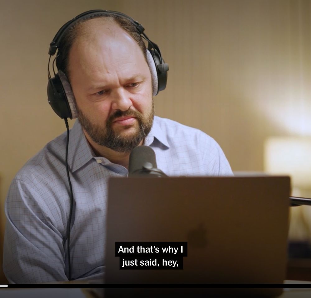 A screen capture from a video from the New York Times website of columnist Ross Douthat staring at a screen while conducting an interview over video chat