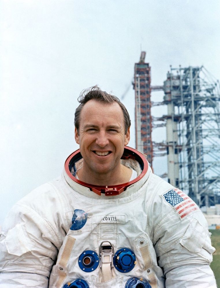 Jim Lovell in a spacesuit in front of a rocket launch pad