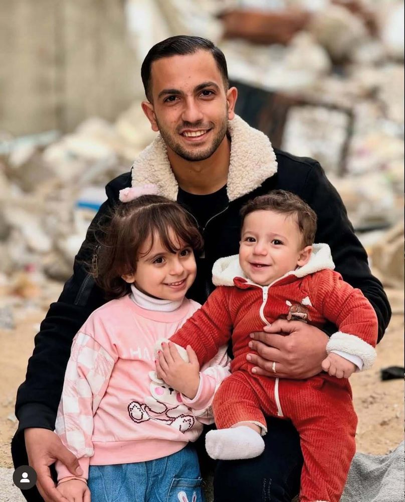 Anas Al-Sharif with children on his lap amidst the rubble of Gaza.