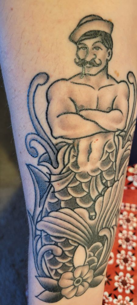 Forearm tattoo of a sailor merman. 