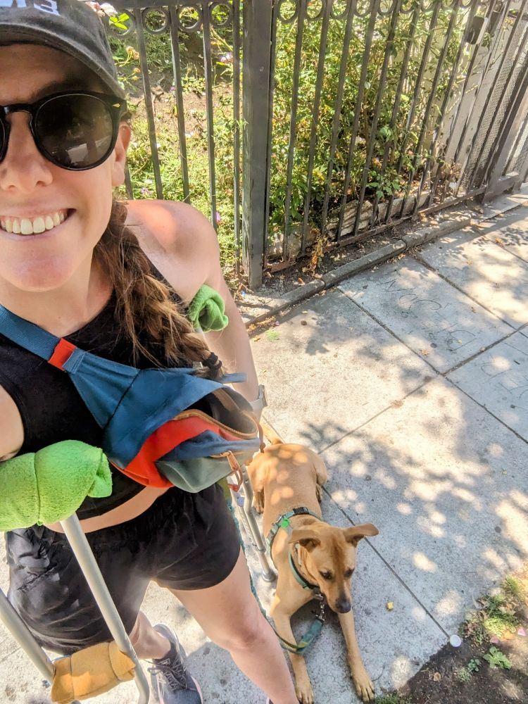 In the lesser outdoors, a girlie with crutches and a winning smile is walking a perfect precious little doggie, who is lying down at her feet like a very well-behaved boy.