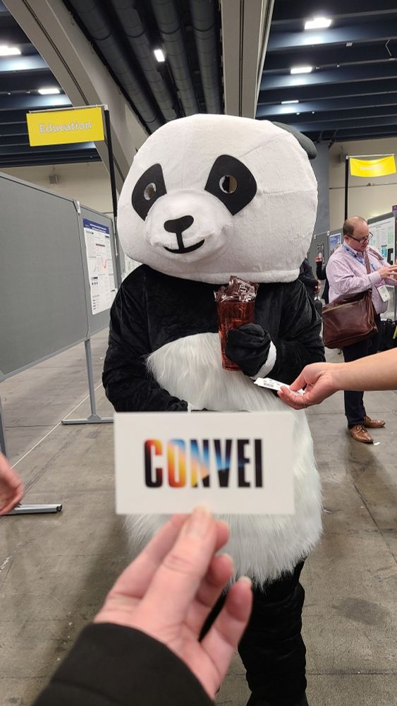 Someone in a panda costume hands out chocolate