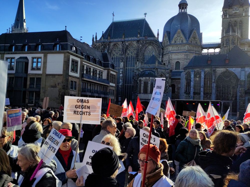 Kundgebung auf dem katschhof in Aachen  mit vielen Flaggen und schildern, im Vordergrund Omas gegen Rechts