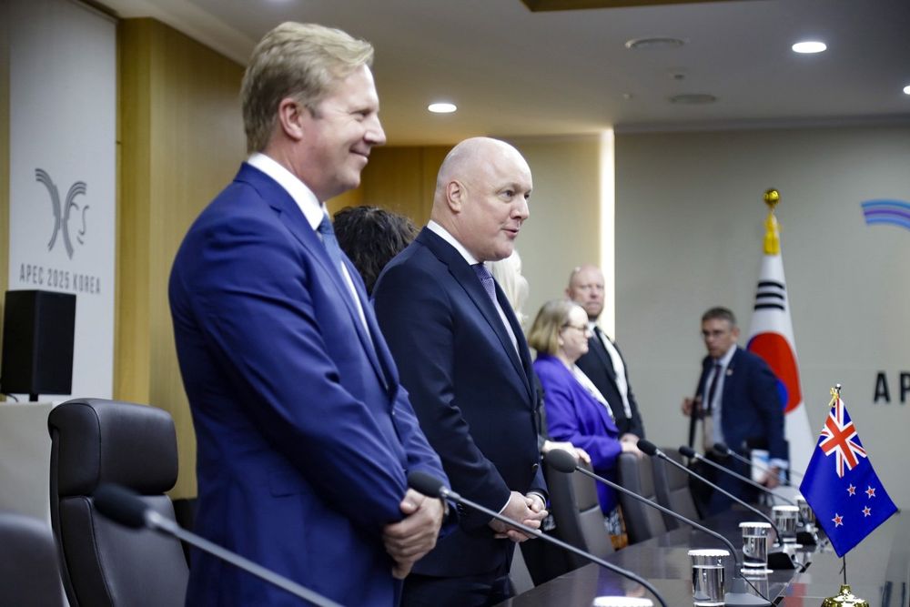 Old mate Christroffer Luxwit doing his crap attempt at the Merkel-Raute seen from the side.

Crap trade negotiator Todd Muffin is standing with his hands crossed normally, refusing to be a co-weirdo.