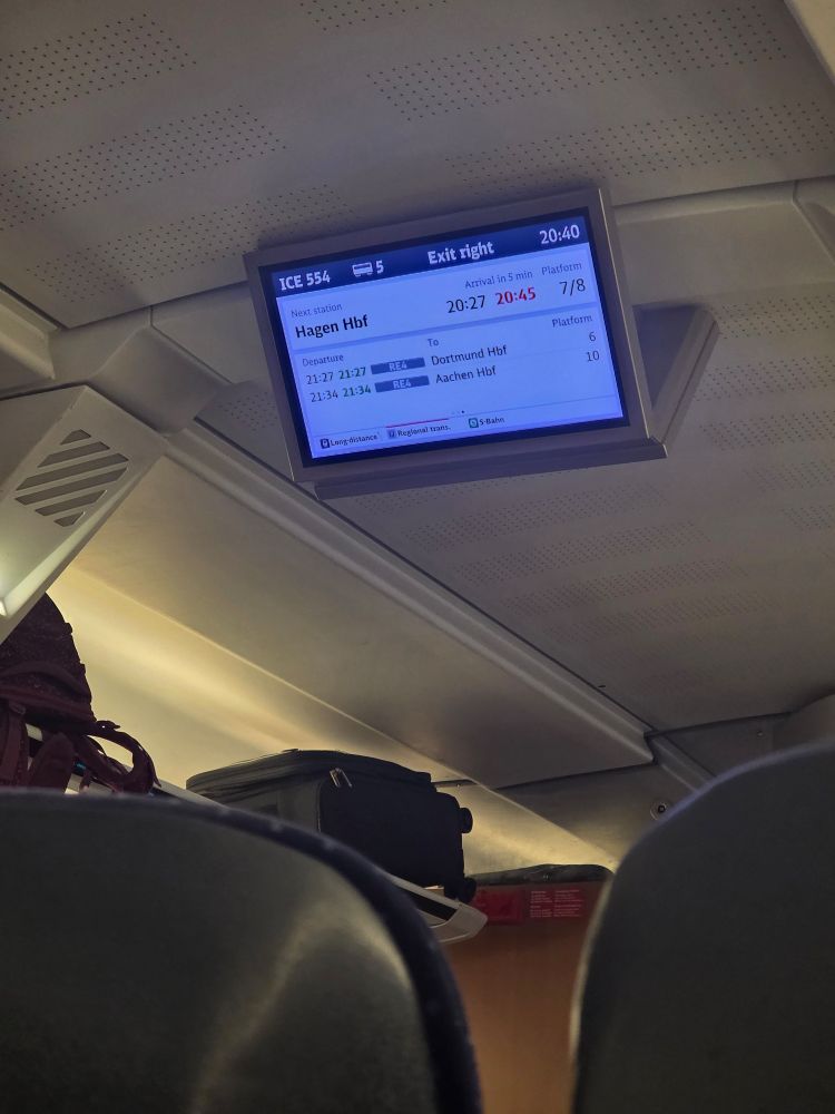 Photo is showing a monitor in a "Deutsche Bahn" Train, showing stops on the way to Köln