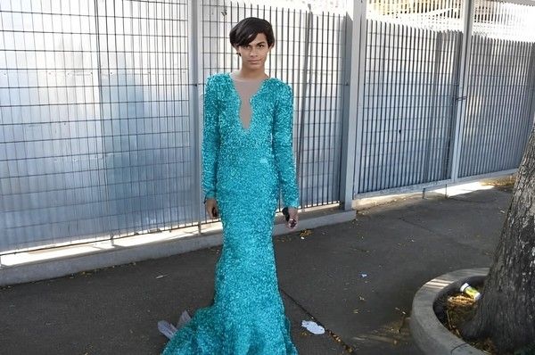 Foto do da lady gaga que viralizou em 2012, na fila para a entrada do show, usando um vestido azul claro brilhante. Ele é um adolescente branco e com cabelo curto e escuro