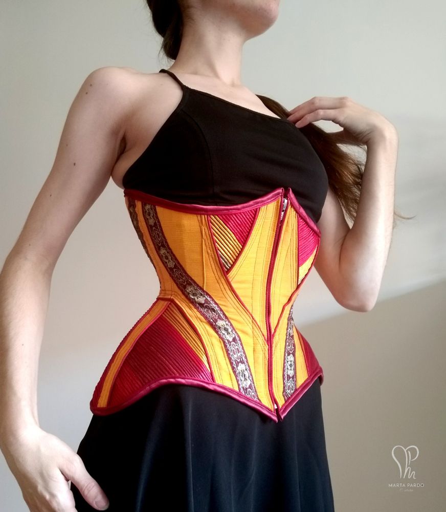 Front view of sample corset I made back in 2020. I drafted the pattern taking inspiration from Edwardian styles, and modernized the finishings. Front zip closure, floating fashion layer with visible colourful cording. Structural layer of coutil and steel boning is invisible from the outside.