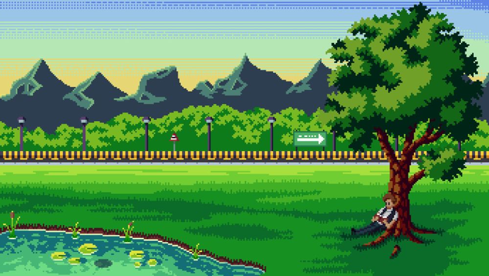 A grassy field with a man reading a book while leaning on a sole tree. There is also a lake nearby. There is a road with a divider at a distance with traffic lights and signs. THere are also trees and mountains in the distance.