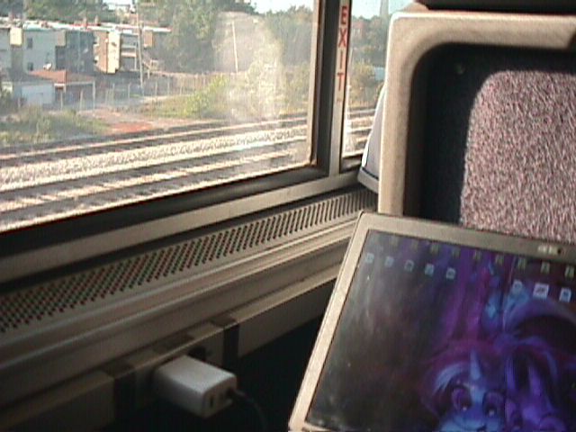 A picture of my laptop and the window of an Amtrak train