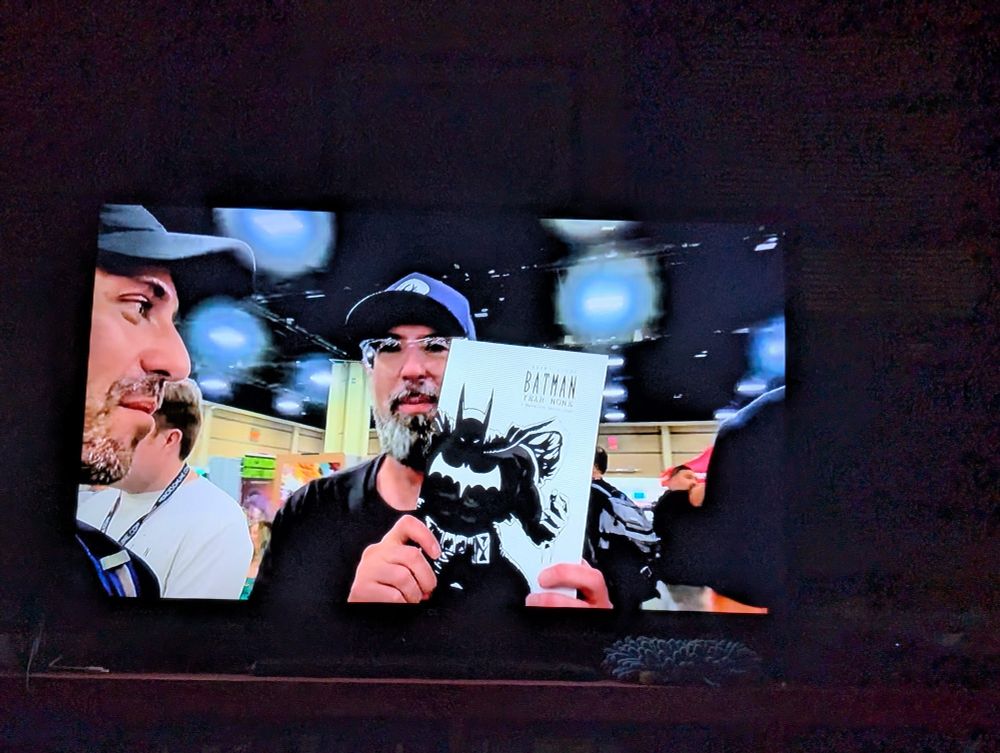 A man holding up a copy of Batman year none by Jeremy Hyler