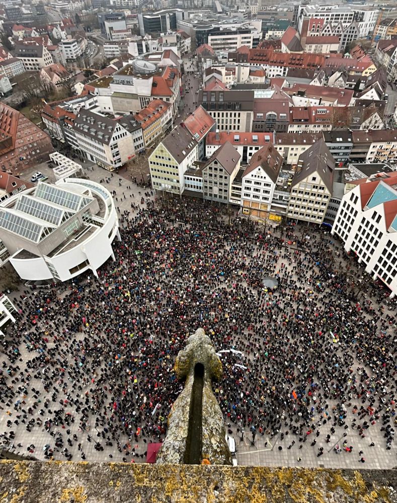 Der Ulmer Münsterplatz aus der Vogelperspektive. Fast der komplette Platz ist mit Menschen gefüllt.
