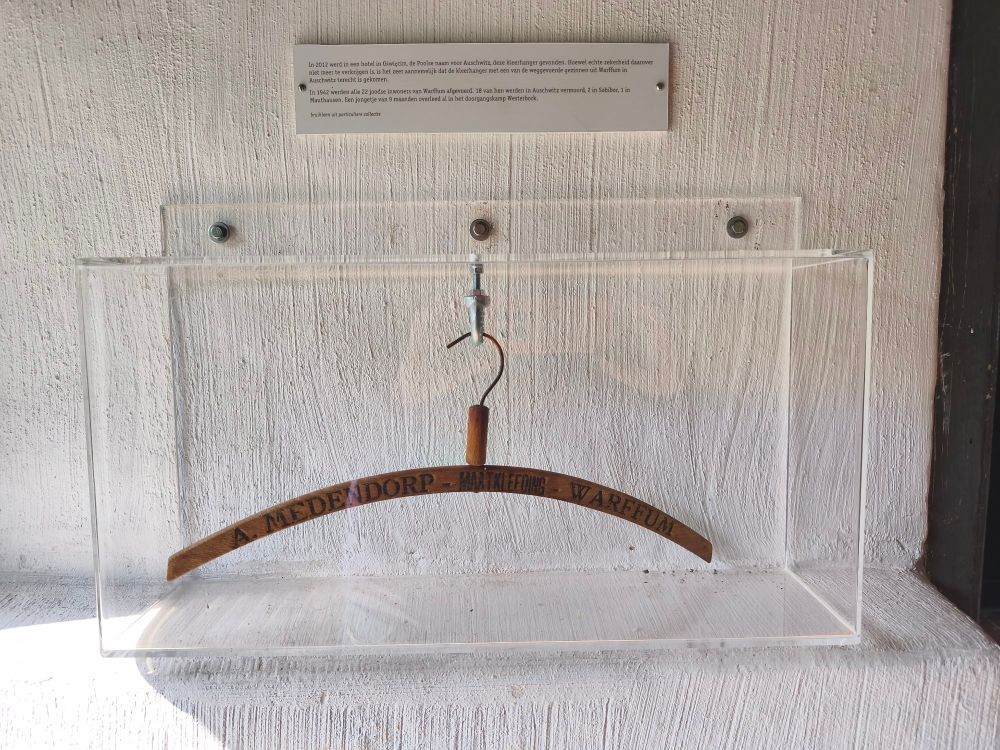Ein Kleiderbügel aus Holz. Auf ihm steht "A. Medendorp Maatkleeding Warffum"